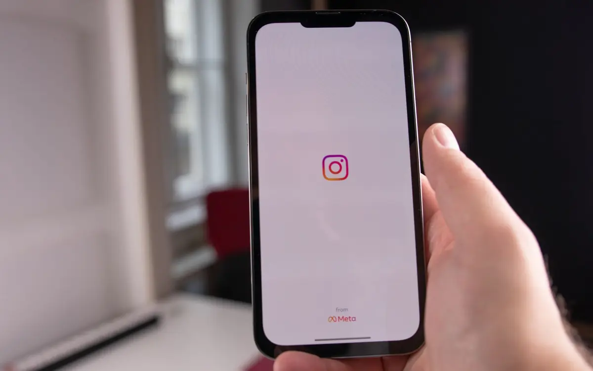 Hand holding a smartphone with the Instagram app open, checking how reels are performing