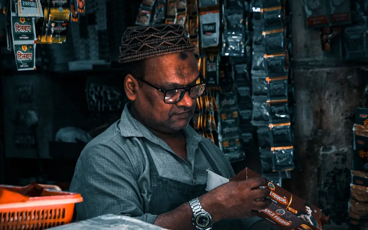Indian shopkeeper arranging products in his store, a local business that can use Meta Ads and Google Ads together